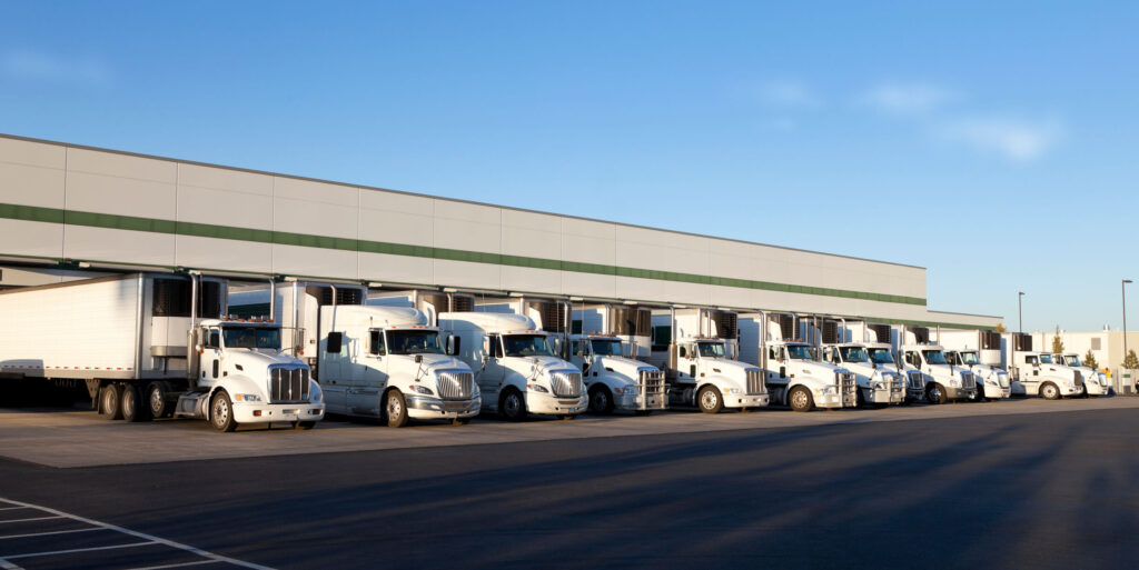 frota de caminhões brancos em um armazém